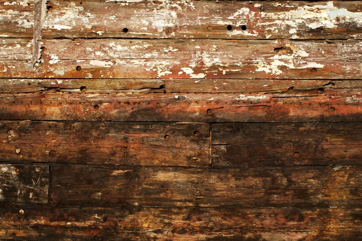 A weathered wooden boat showing rust, emphasizing the importance of wood mold removal in Jacksonville, FL.